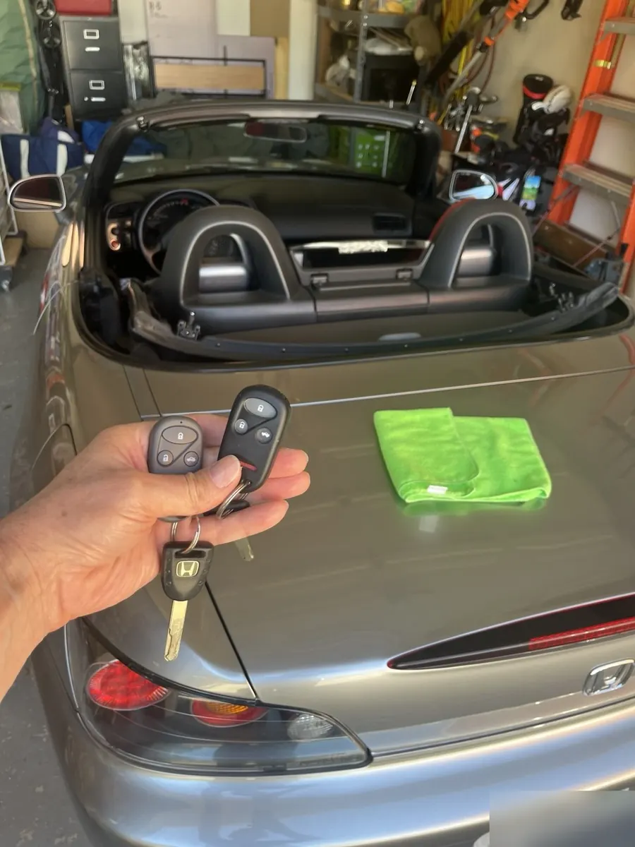Two remote keys and a transponder key for a Honda S2000 in a home garage