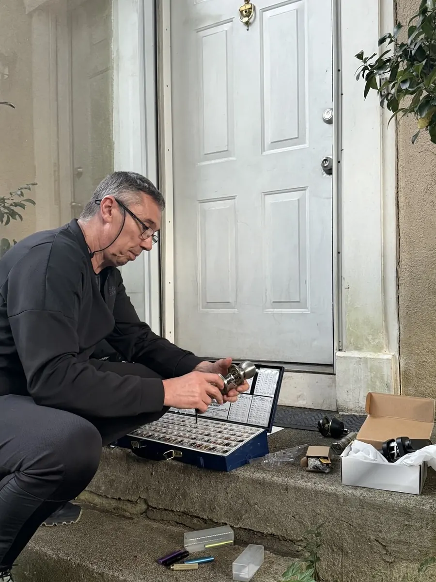 Technician rekeying a door knob with a pinning kit on a front step